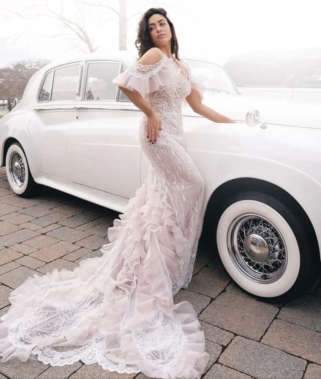 Model wearing Bridal dress leaning next to a car